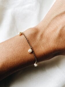 Pulseira em Aço Dourada com Pérolas Pequeninas Penduradas