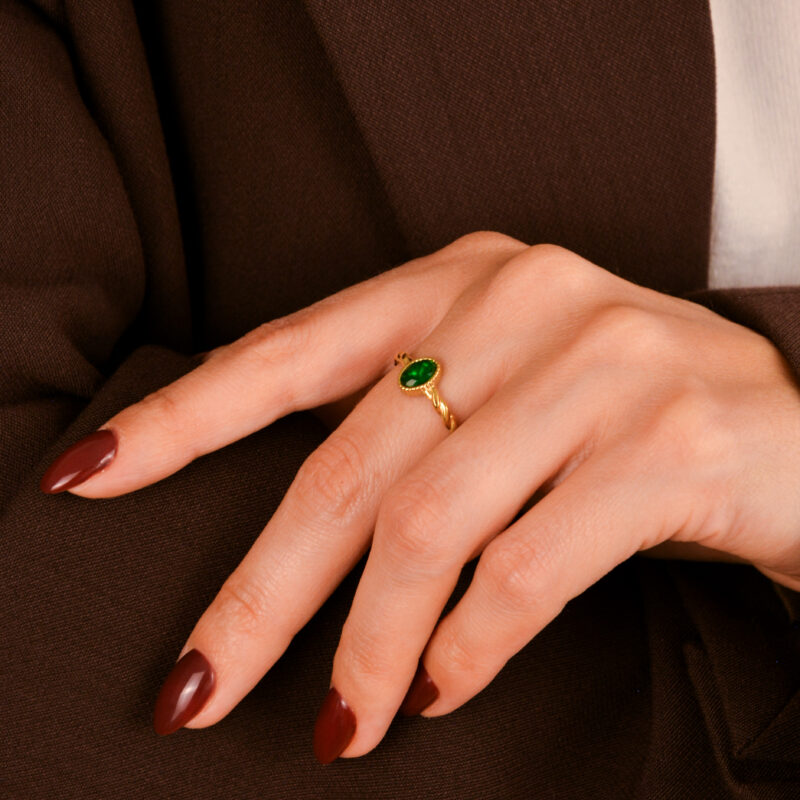 O Anel em Aço Dourado Torcido com Pedra Verde é uma verdadeira joia de presença — elegante, ousado e cheio de charme.